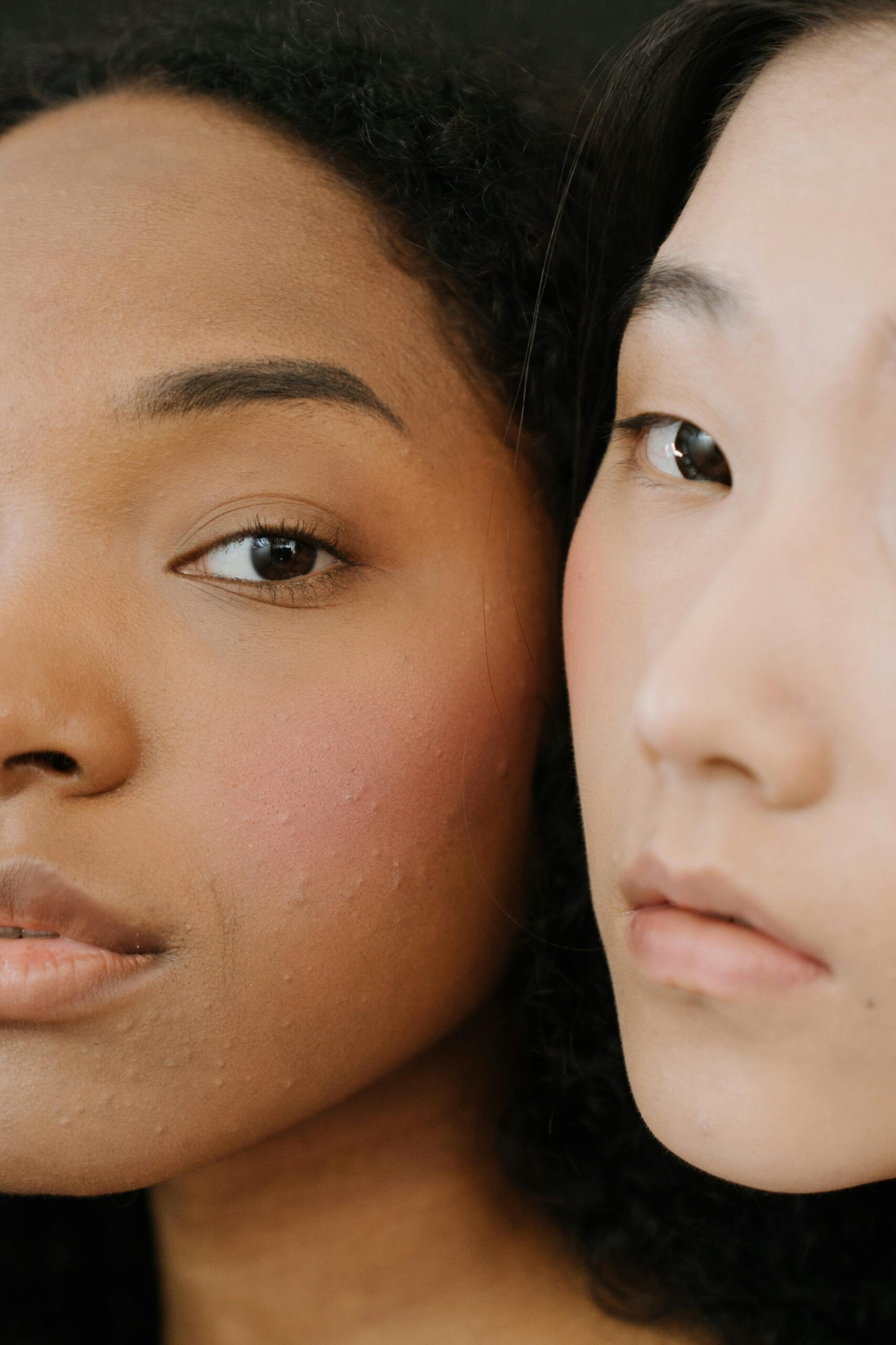 Close-up portrait of two women showcasing diverse beauty and natural skin.